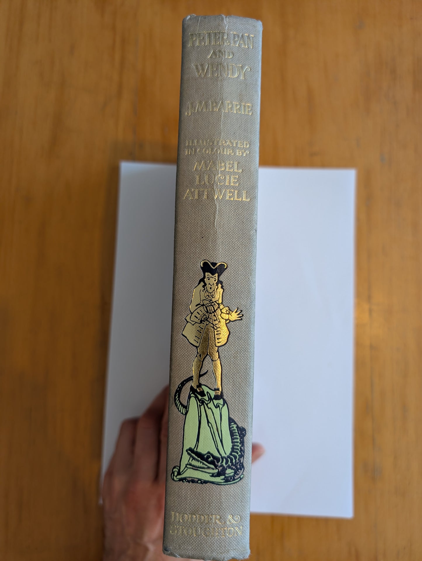 Vintage book with a decorative cover featuring an illustration on a wooden surface