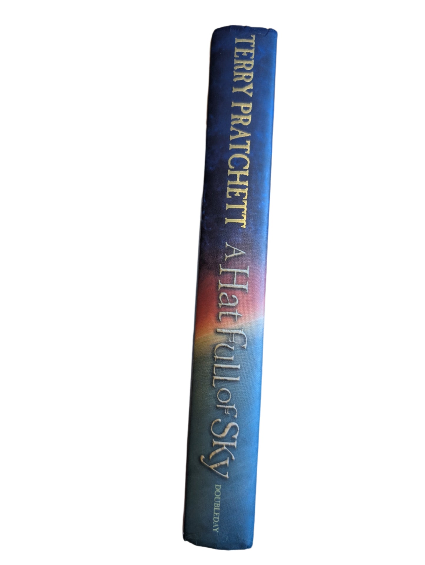 Book titled 'A Hatful of Sky' by Terry Pratchett on a wooden surface