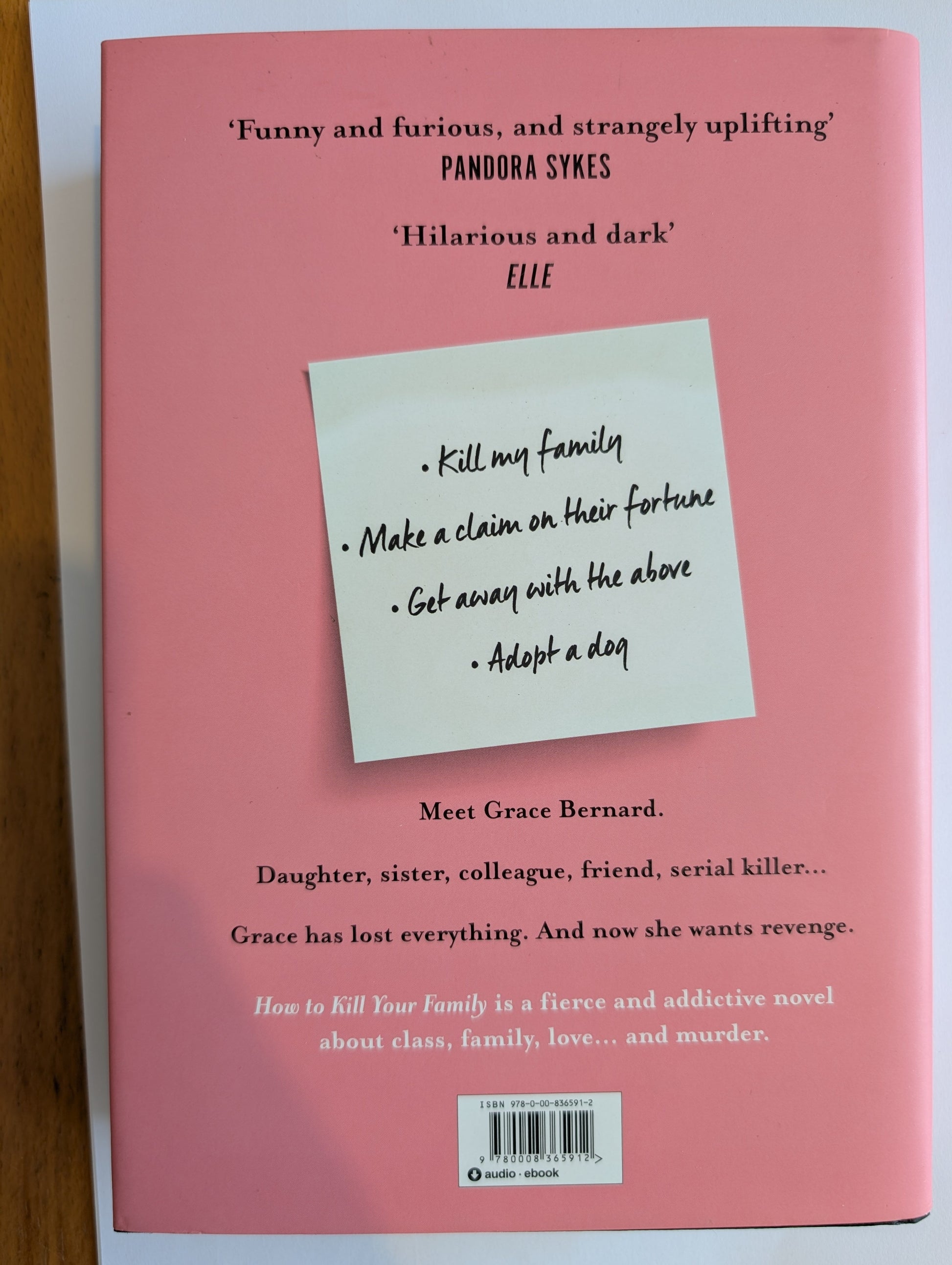 Book cover with a sticky note on a pink background