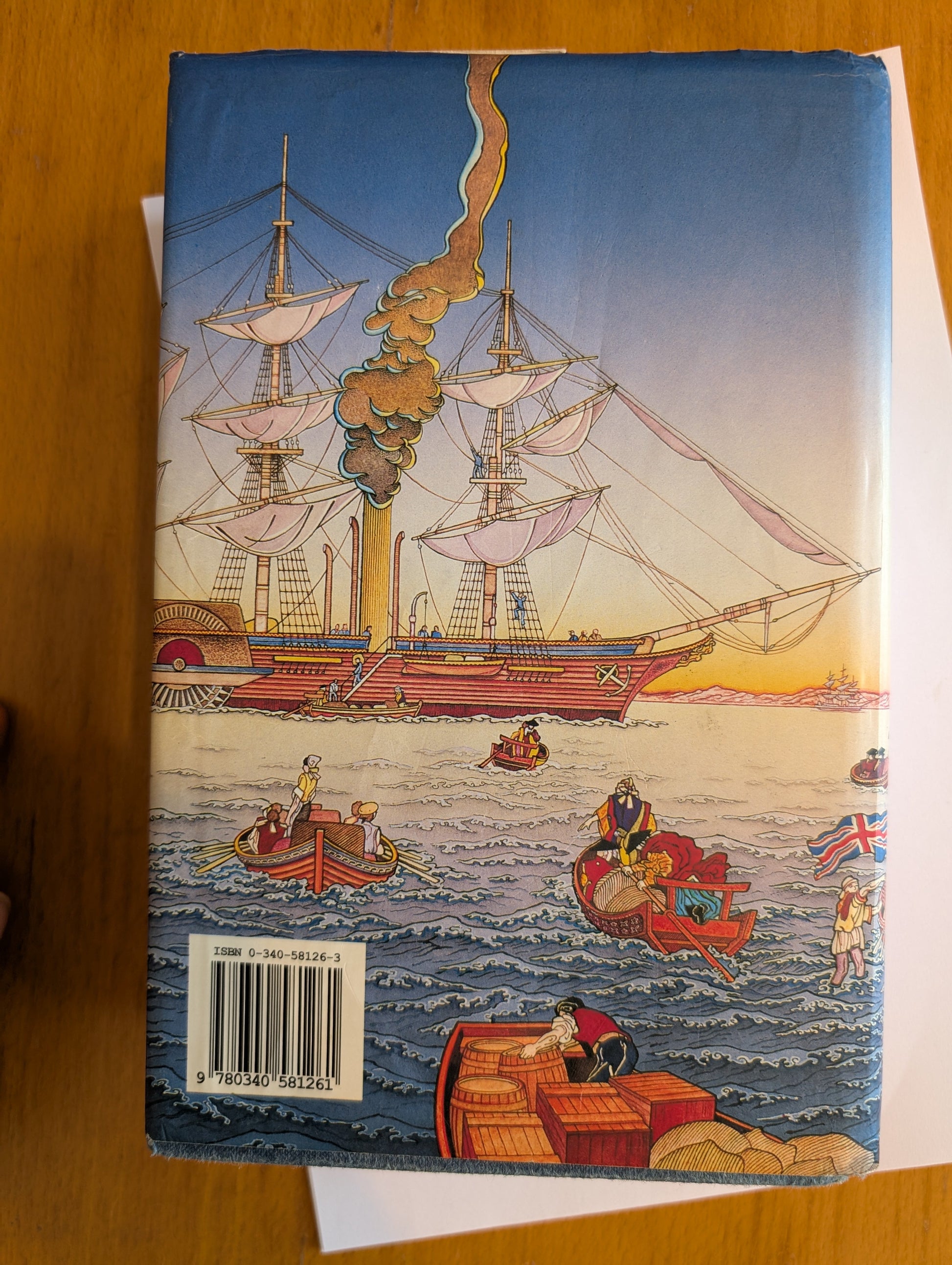 Book cover with a ship illustration on a wooden surface