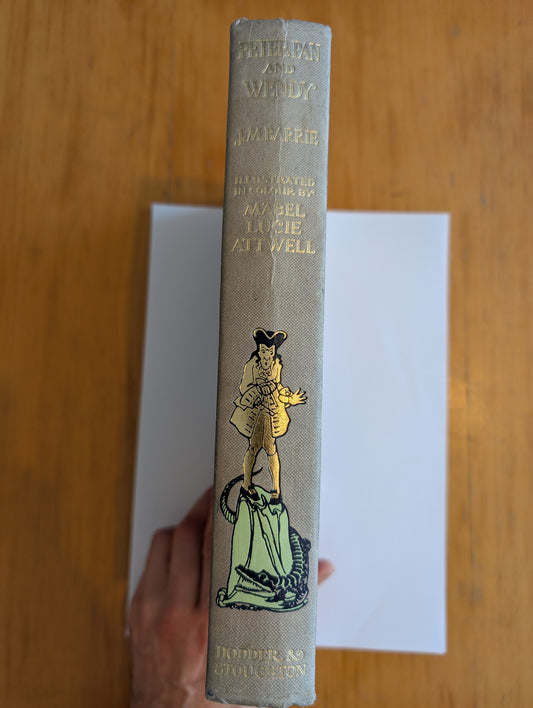 Vintage book with a decorative cover featuring an illustration on a wooden surface