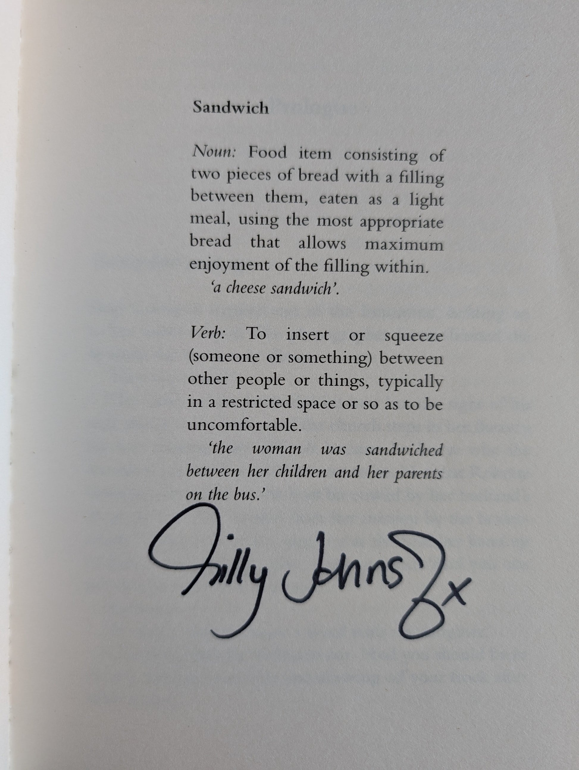 Text definition of a sandwich with a signature on a gray background