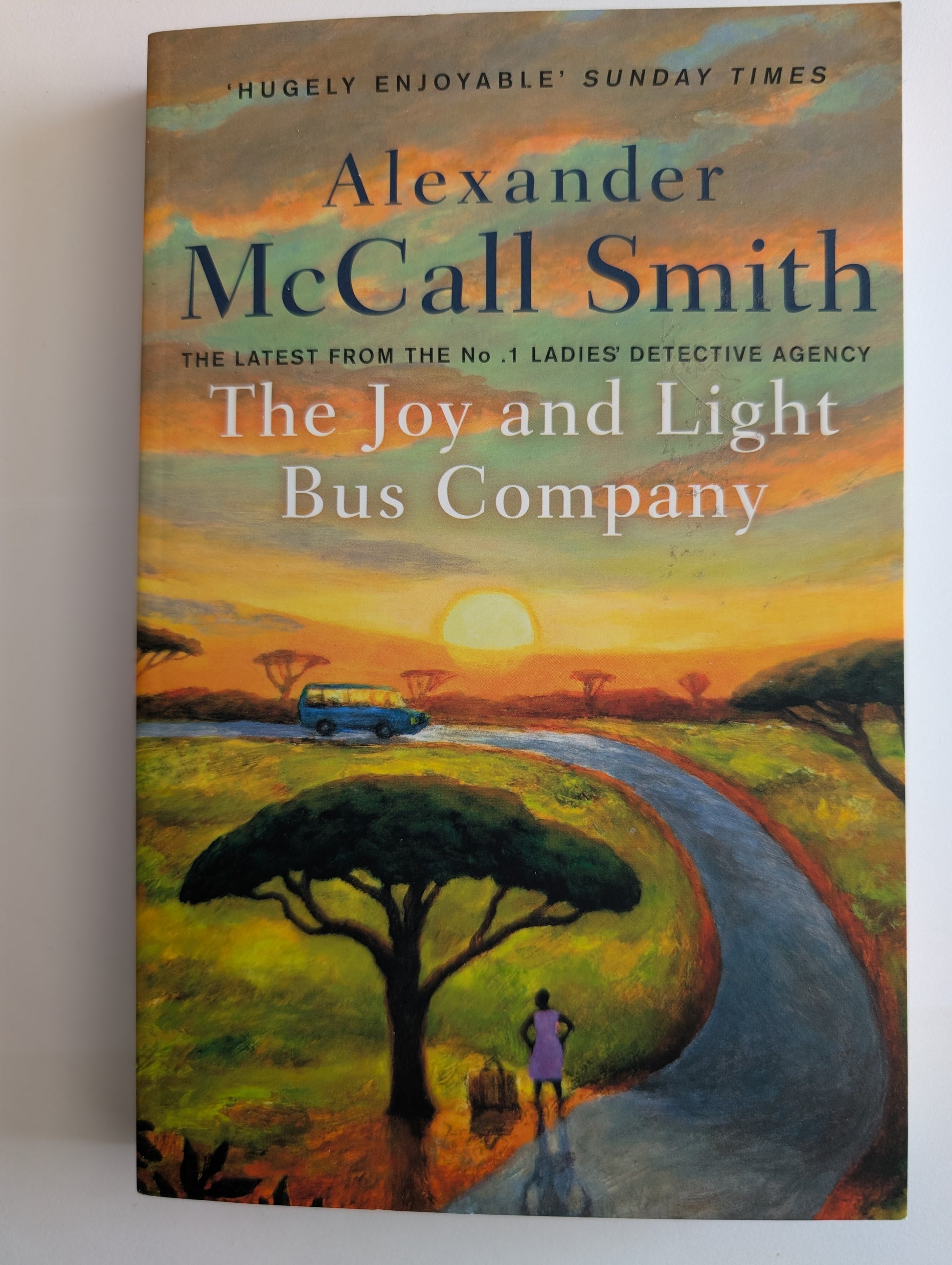 Book cover of 'The Joy and Light Bus Company' by Alexander McCall Smith with a scenic illustration.