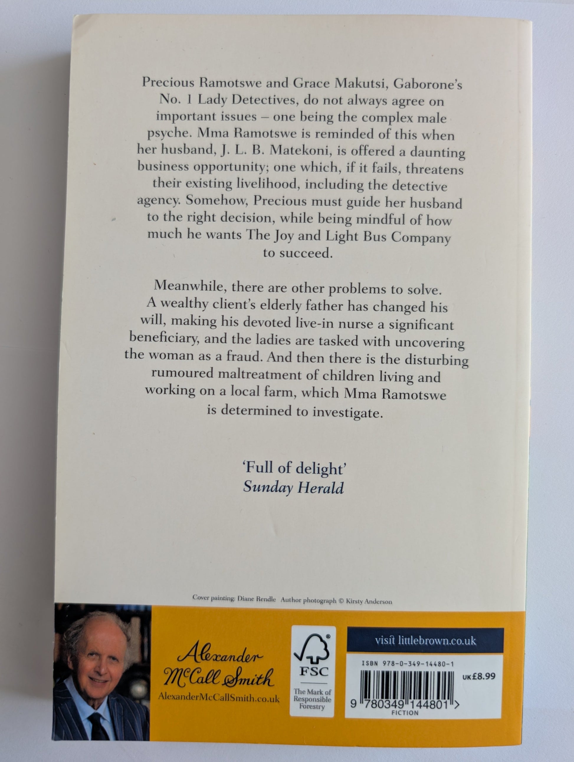 Back cover of a book with text and a signature on a white background